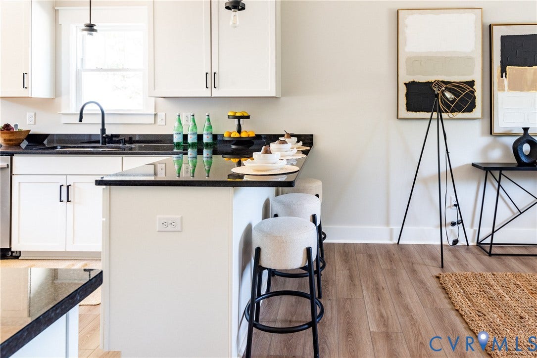 1343 Stokes Station Road, Goochland, VA 23063 White shaker cabinetry, dark countertops, a built-in kitchen island, a stainless steel dishwasher