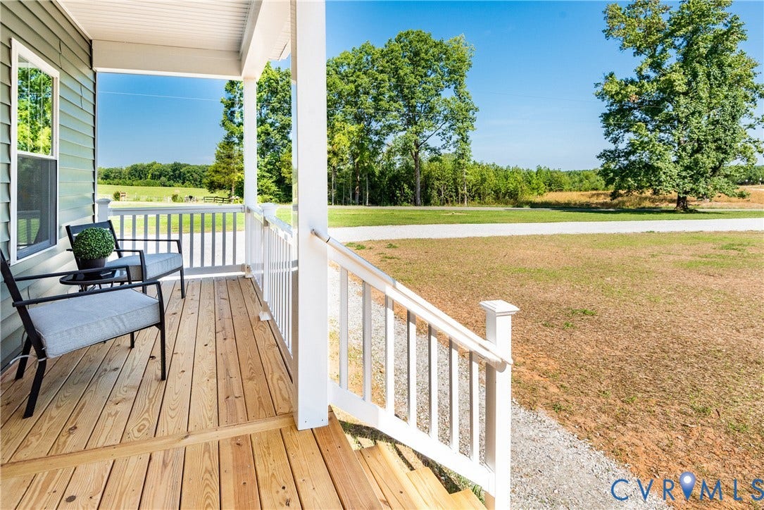 1343 Stokes Station Road, Goochland, VA 23063 Inviting front porch with natural wood decking, white railing, and exterior siding