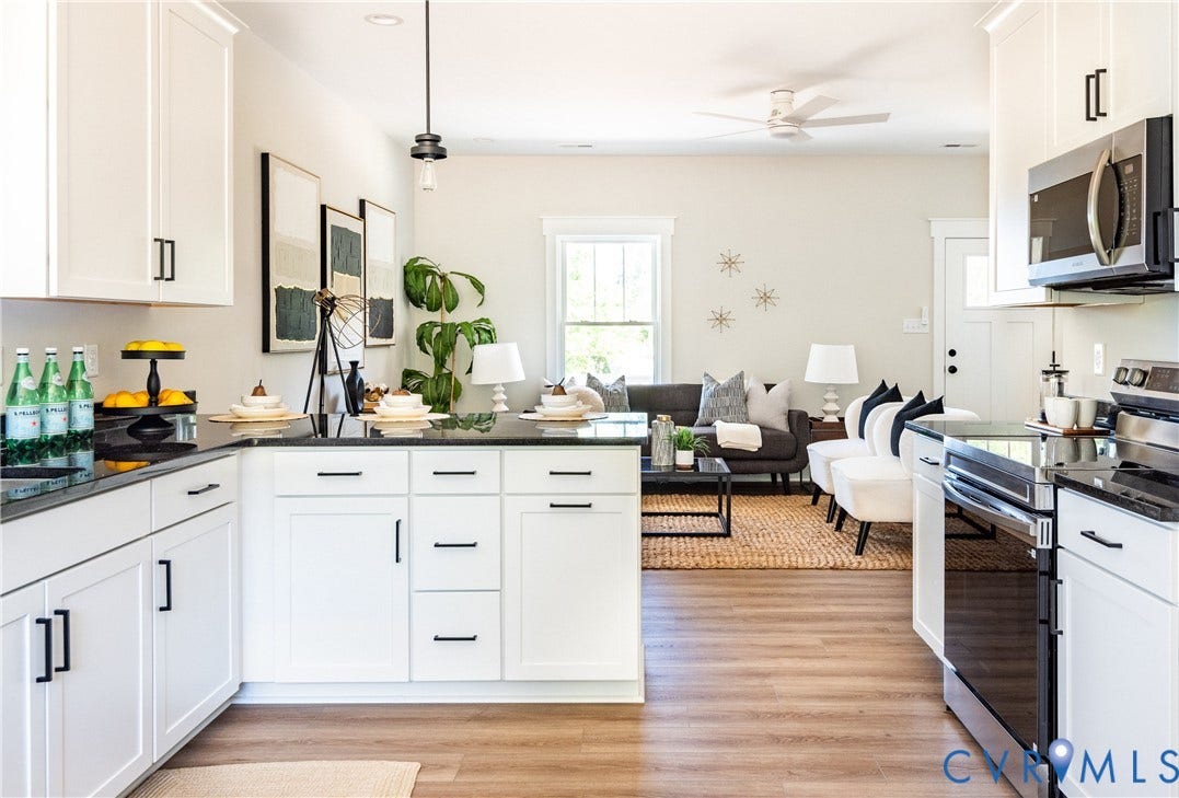 1343 Stokes Station Road, Goochland, VA 23063 Open-concept design featuring wood-finish flooring, white cabinetry with black hardware, dark countertops, and stainless steel appliances