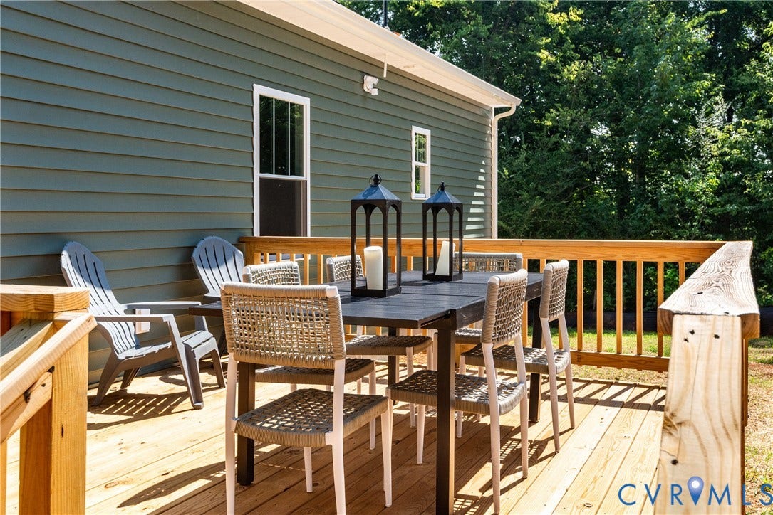 1343 Stokes Station Road, Goochland, VA 23063 Expansive wood deck with natural wood railing, siding exterior in a rich green hue, and white-framed windows