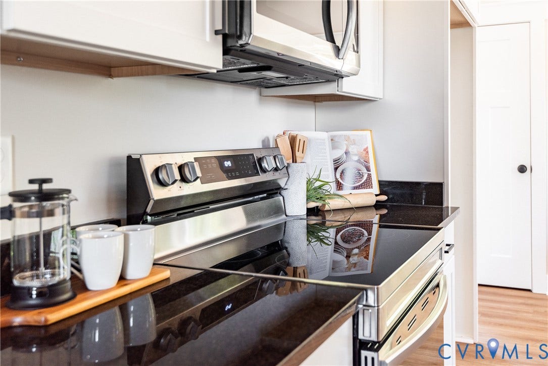 1343 Stokes Station Road, Goochland, VA 23063 Stainless steel range with a built-in microwave, dark countertops, and white upper cabinetry