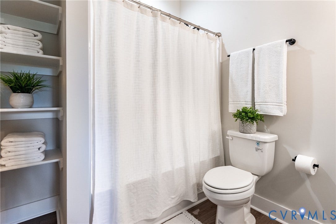 1343 Stokes Station Road, Goochland, VA 23063 Built-in shelving, a white toilet, a shower curtain rod, a black towel bar