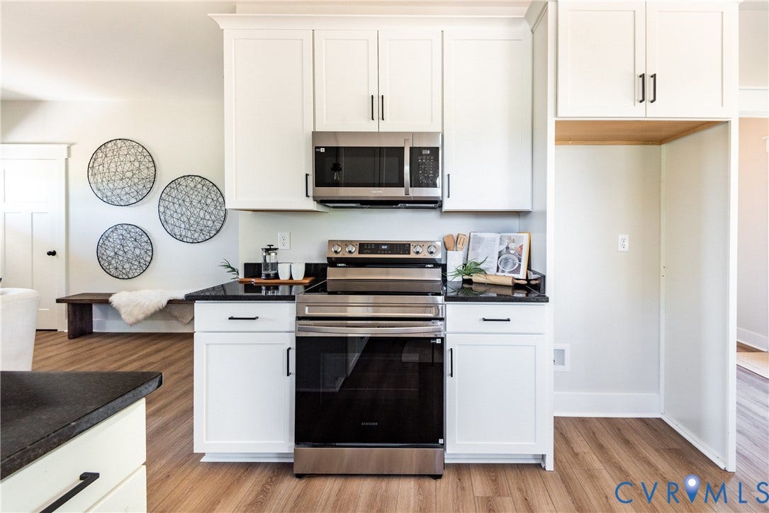 1343 Stokes Station Road, Goochland, VA 23063 White shaker cabinetry with black hardware, stainless steel appliances, black countertops