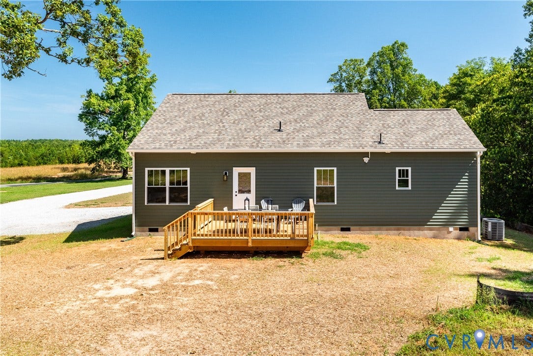 1343 Stokes Station Road, Goochland, VA 23063 Dark green siding exterior with a light wood deck, shingle roof, and white-framed windows