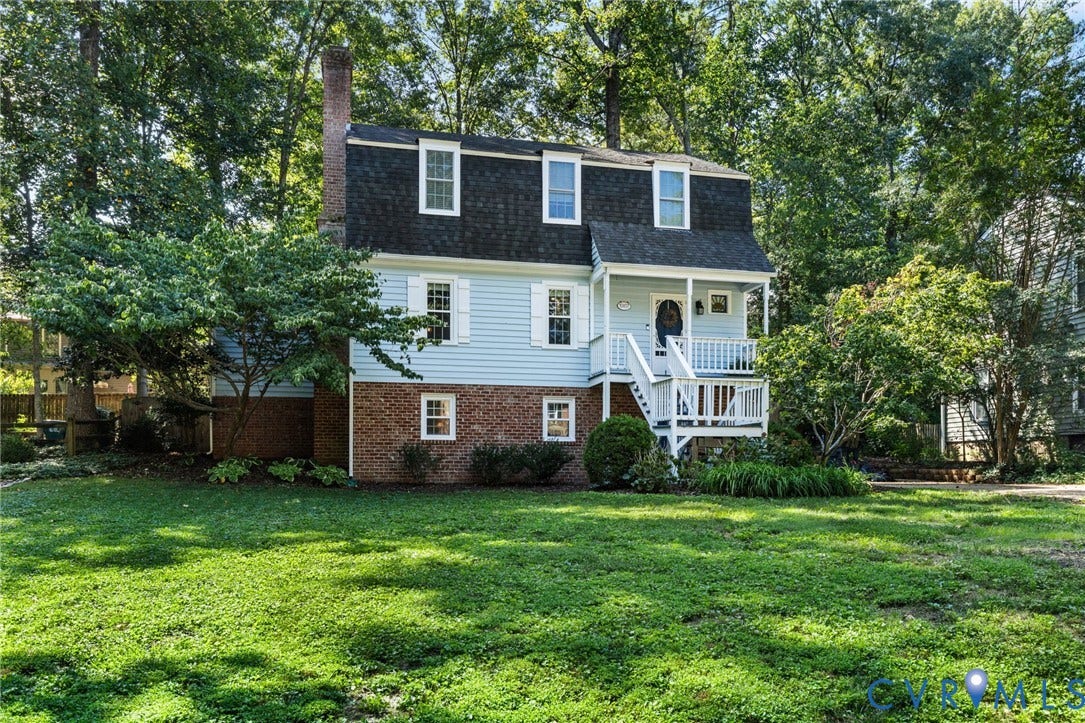 10407 Silverbrook Drive, Henrico, VA 23233 Two-story exterior with light blue siding, brick foundation, dormer windows, and a covered porch with white railings