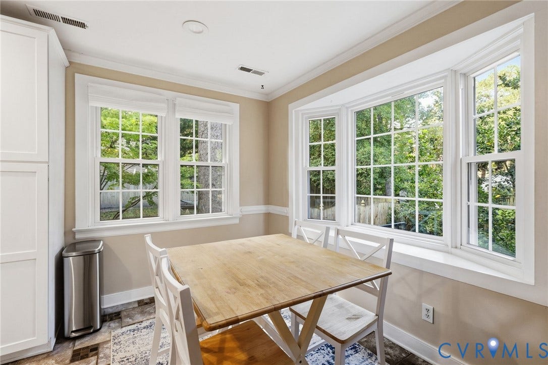 10407 Silverbrook Drive, Henrico, VA 23233 White cabinetry, crown molding, wall paneling, and a large bay window with multiple panes