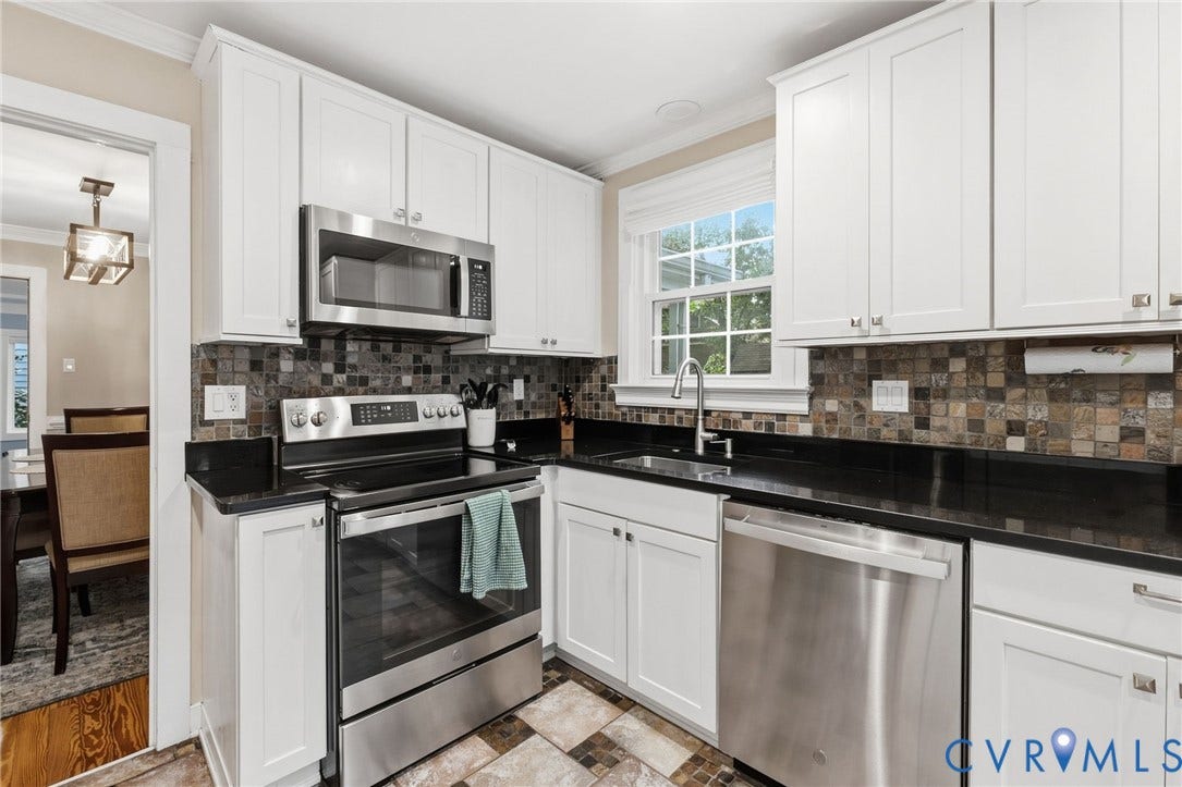 10407 Silverbrook Drive, Henrico, VA 23233 White shaker cabinetry with dark countertops, stainless steel appliances, and a mosaic tile backsplash