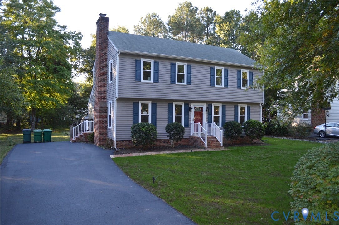 10227 Acworth Drive, Glen Allen, VA 23060 Two-story residence featuring siding exterior, a brick chimney, and a front entry with a red door