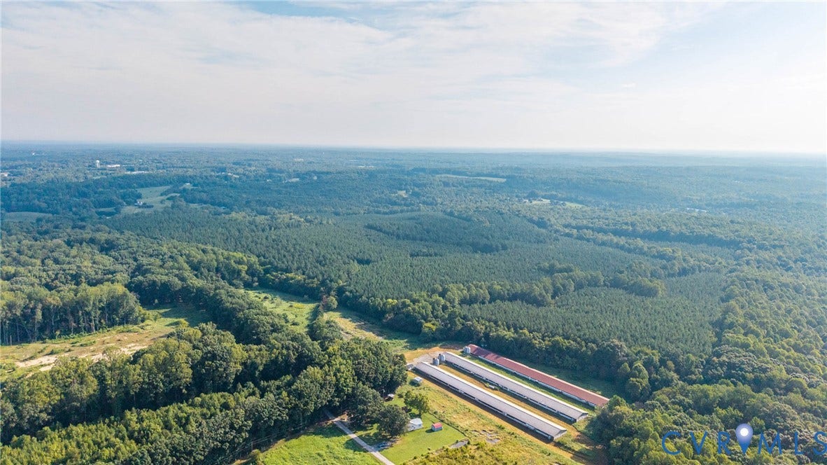 78 Bowling Lane, Cumberland, VA 23040 Expansive wooded landscape with three long agricultural buildings and cleared land areas