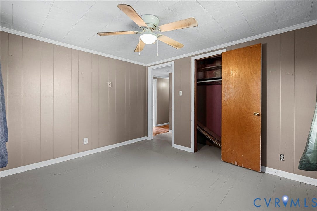 78 Bowling Lane, Cumberland, VA 23040 Painted wood-finish wall paneling, painted concrete flooring, ceiling fan with light fixture, and an integrated closet with wood-finish door