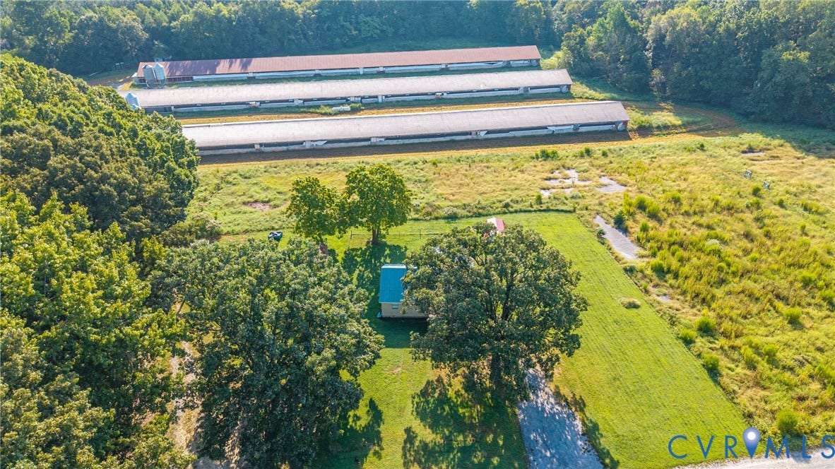 78 Bowling Lane, Cumberland, VA 23040 Expansive lot featuring a partially paved drive, mature trees, open grassy areas, and multiple long-span structures