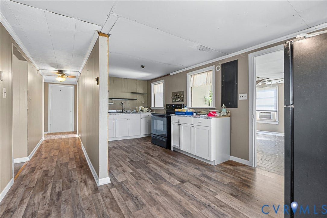 78 Bowling Lane, Cumberland, VA 23040 Wood-finish flooring throughout, white cabinetry, a black built-in range, and a ceiling fan in the hallway