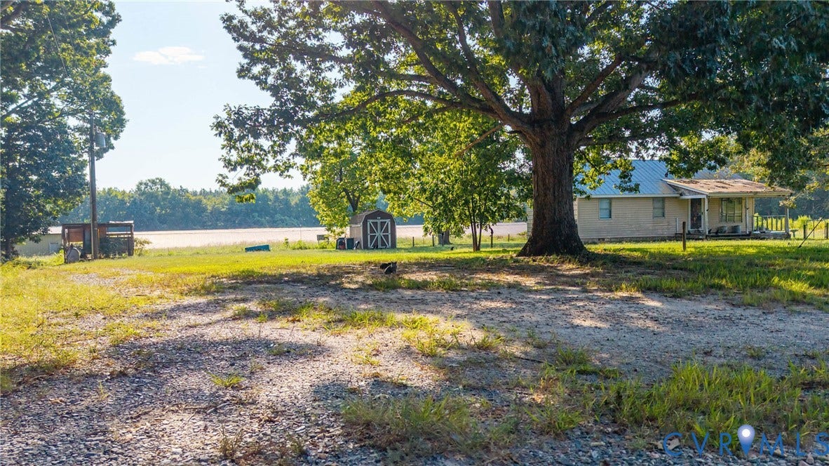 78 Bowling Lane, Cumberland, VA 23040 Single-story residence with a metal roof, a covered porch, and a gravel driveway
