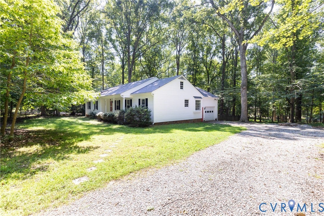 2765 Briarpatch Lane, Powhatan, VA 23139 White siding exterior with a dark roof, attached single-car garage, and mature trees