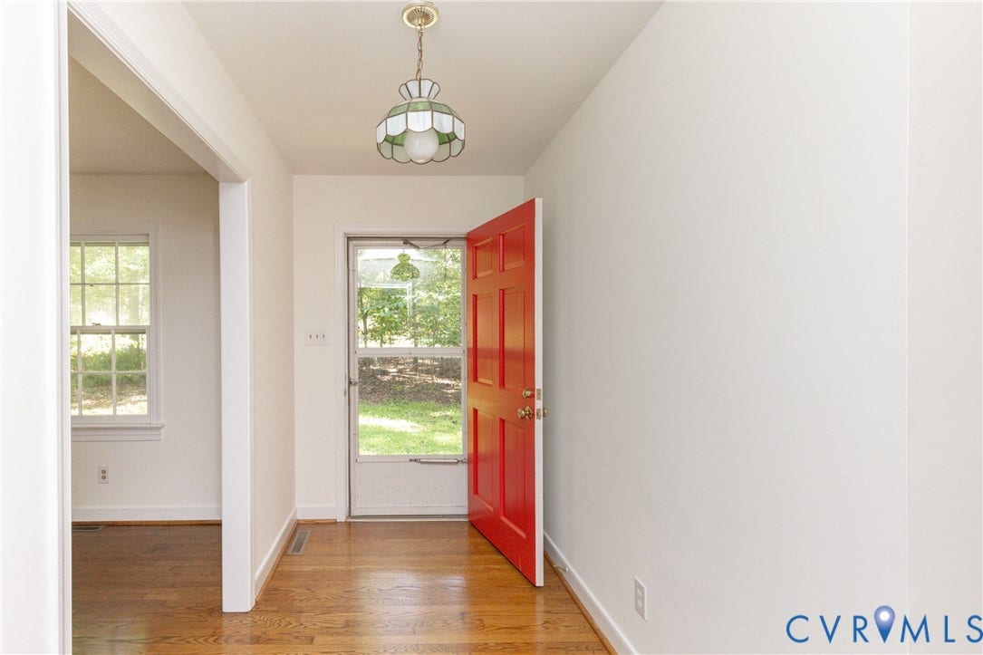 2765 Briarpatch Lane, Powhatan, VA 23139 Entryway with wood-finish flooring, a bright red paneled door, and an ornate ceiling light fixture