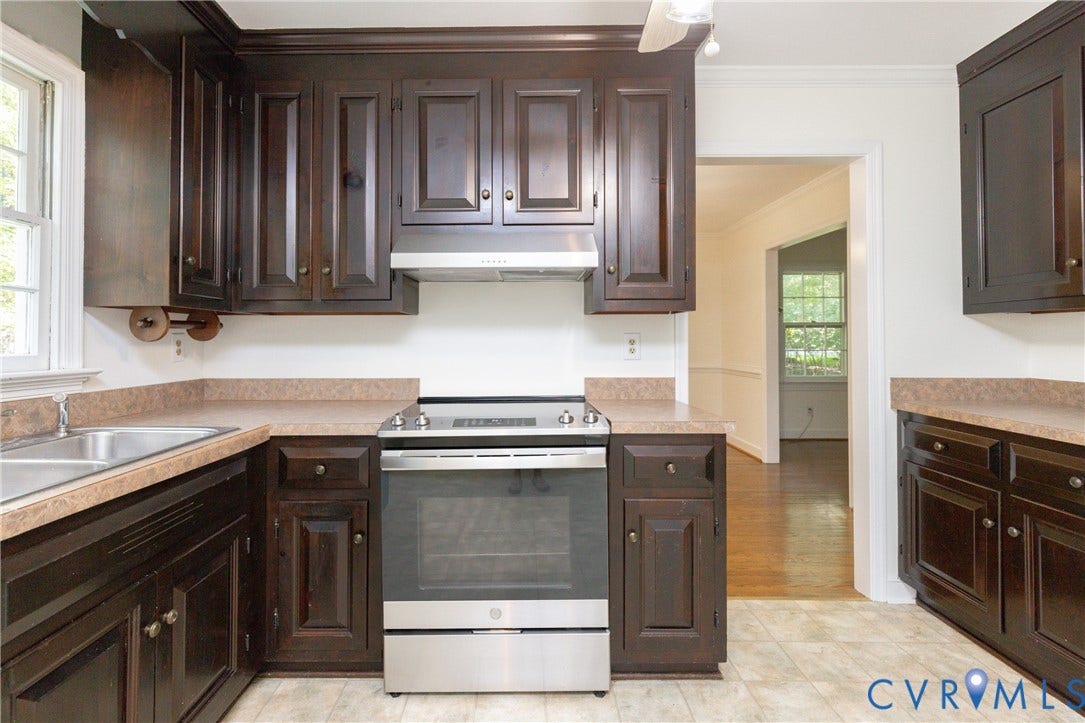 2765 Briarpatch Lane, Powhatan, VA 23139 Dark wood cabinetry paired with a stainless steel range and coordinating range hood