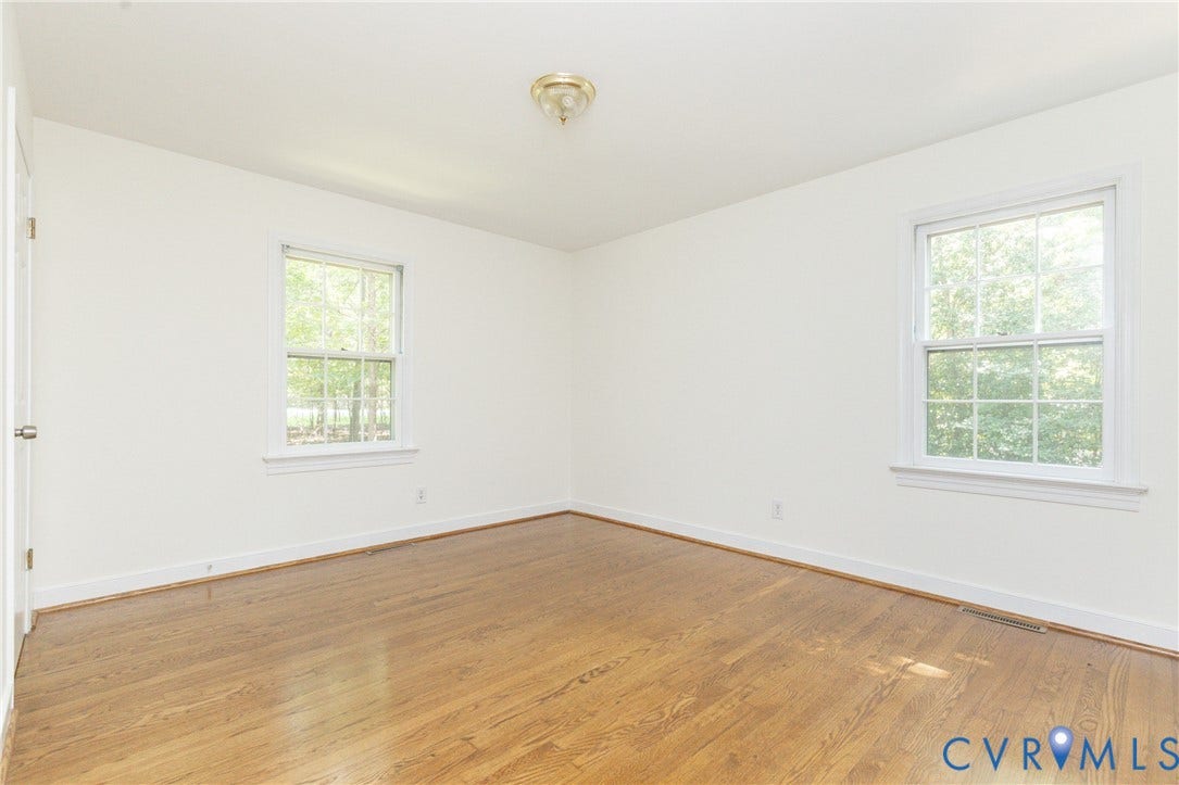 2765 Briarpatch Lane, Powhatan, VA 23139 Hardwood flooring, white walls, two white-framed windows, and a ceiling-mounted light fixture