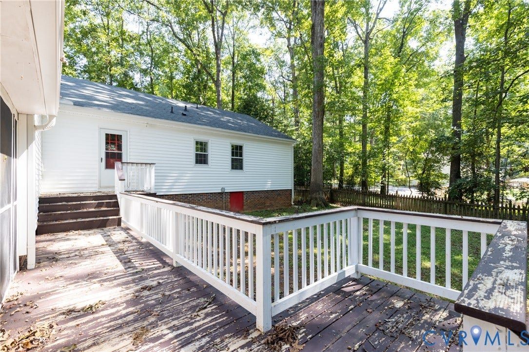 2765 Briarpatch Lane, Powhatan, VA 23139 Expansive composite deck with white vinyl railings and multiple levels, surrounded by mature wooded landscape