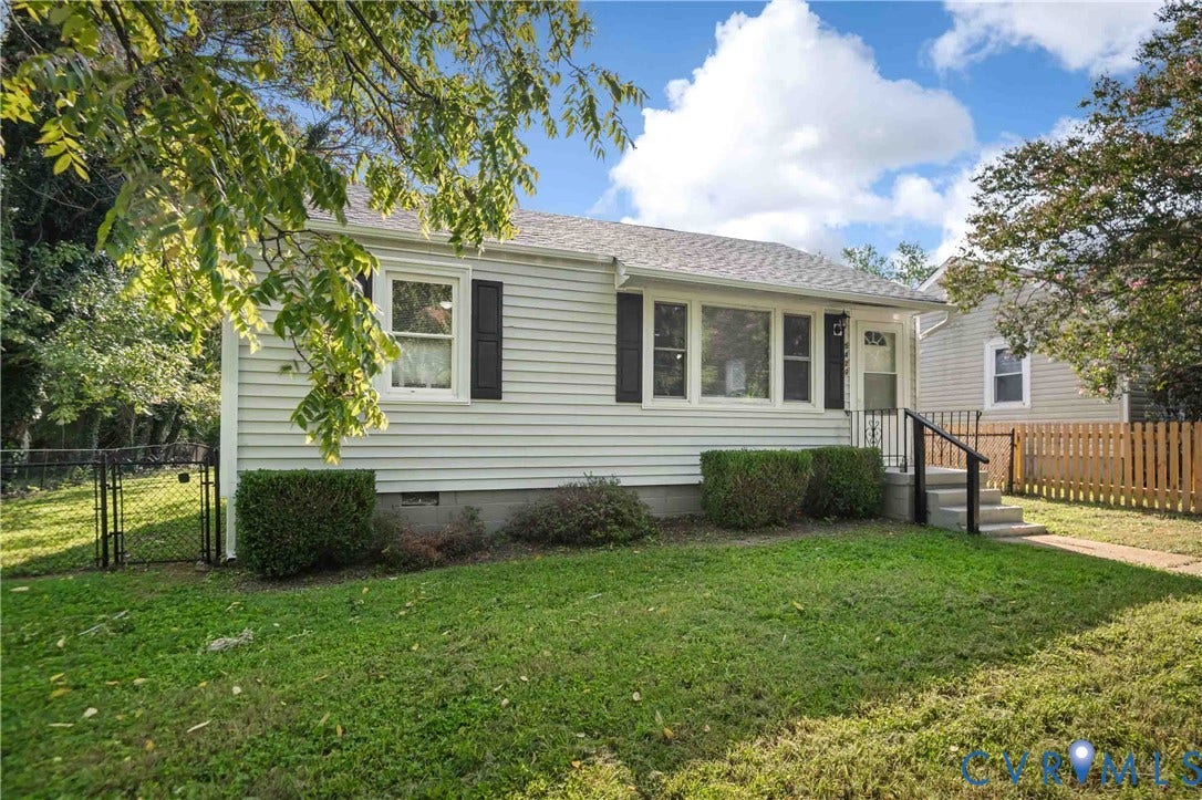 5429 Parker Street, Fulton Hill, Richmond, VA 23231 White siding exterior with black shutters, mature landscaping, concrete porch with railing, and a fenced yard
