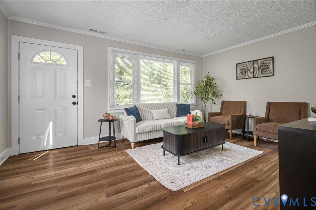5429 Parker Street, Fulton Hill, Richmond, VA 23231 Wood-finish flooring, white paneled door with an arched glass insert, large multi-pane window, and light neutral wall paint