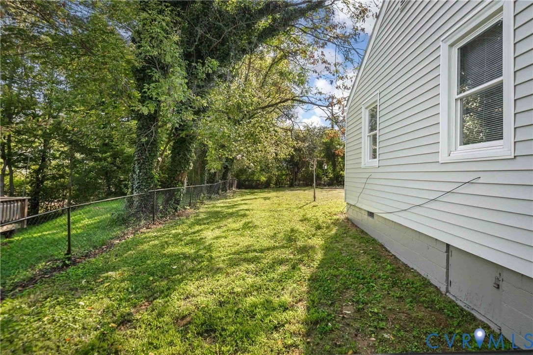 5429 Parker Street, Fulton Hill, Richmond, VA 23231 Expansive side yard featuring a chain-link fence, mature trees, and a wooden deck