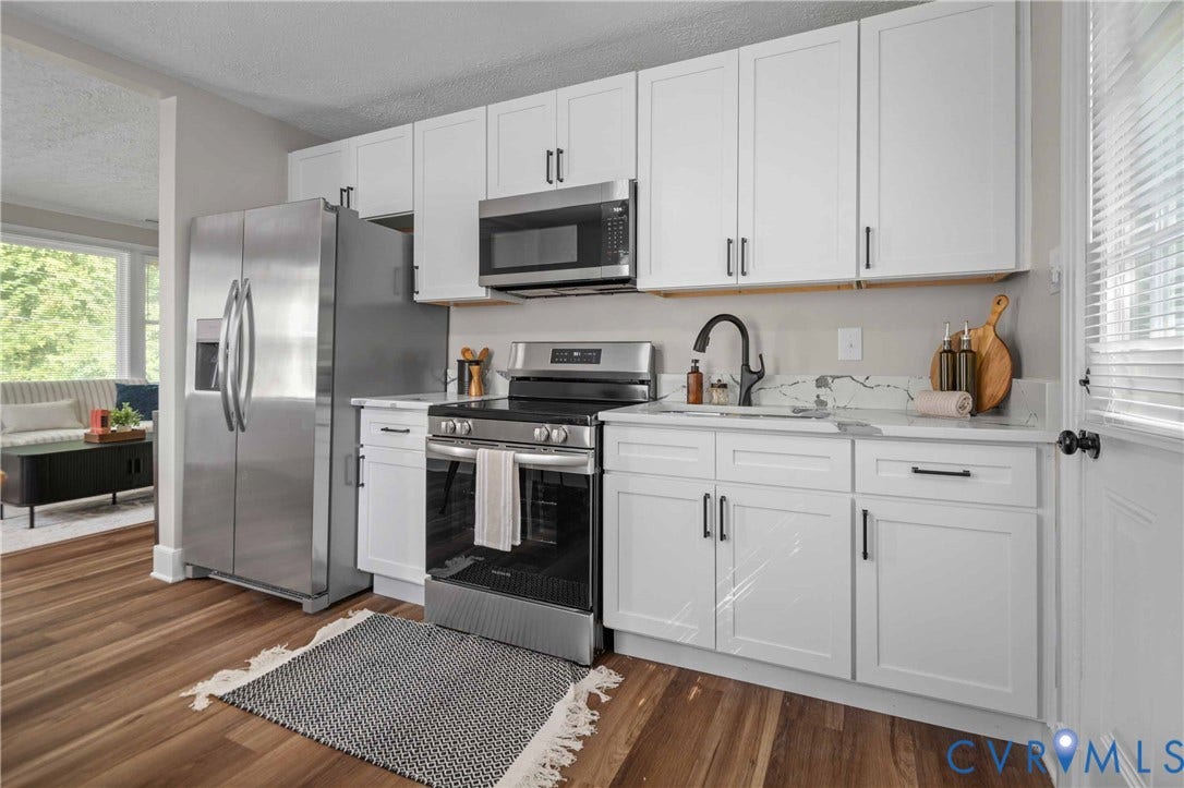5429 Parker Street, Fulton Hill, Richmond, VA 23231 Modern kitchen featuring white shaker cabinetry, stainless steel appliances, wood-finish flooring, a matte black faucet, and light-toned countertops