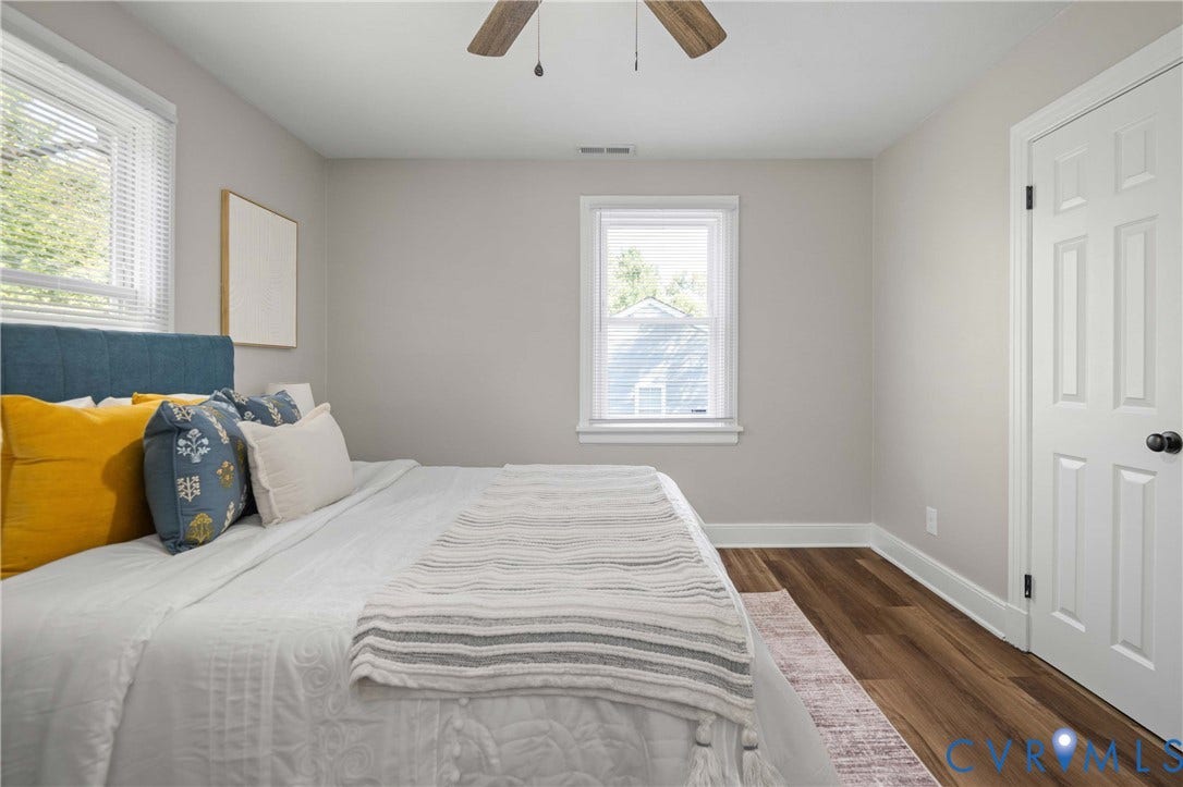 5429 Parker Street, Fulton Hill, Richmond, VA 23231 Wood-finish flooring, two large windows with blinds, neutral wall paint, white trim, and a ceiling fan
