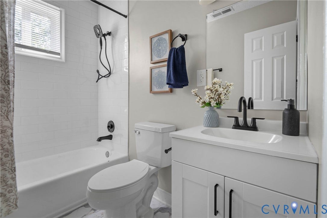 5429 Parker Street, Fulton Hill, Richmond, VA 23231 White subway tile surround, matte black fixtures, built-in bathtub, white vanity with integrated sink, and undermount cabinetry