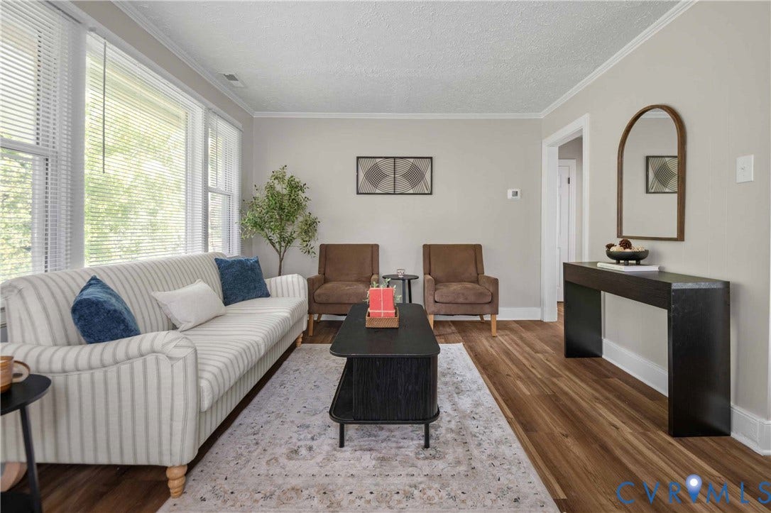 5429 Parker Street, Fulton Hill, Richmond, VA 23231 Spacious living area featuring expansive windows, crown molding, wood-finish flooring, and light-toned wall paint