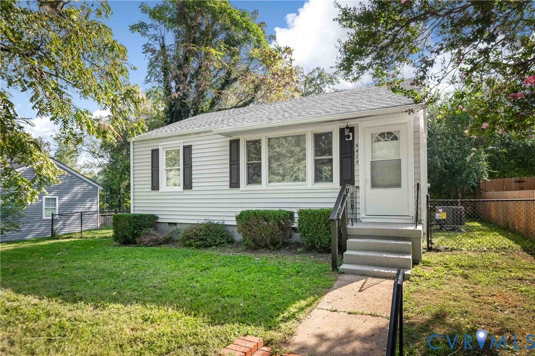 5429 Parker Street, Fulton Hill, Richmond, VA 23231 White siding exterior with black shutters, mature landscaping, concrete front steps, and a chain-link fence