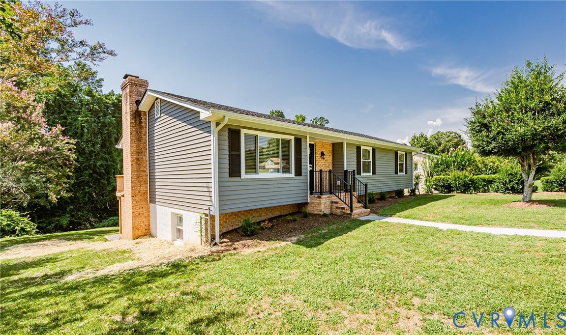 2702 Manchester Drive, New Birchett Estates, Prince George, VA 23875 Light gray siding exterior with dark shutters, front porch with black railing, brick chimney, and concrete walkway