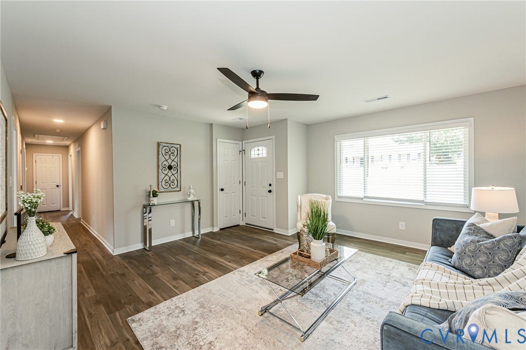 2702 Manchester Drive, New Birchett Estates, Prince George, VA 23875 Wood-finish flooring throughout, light gray wall finishes, a ceiling fan with integrated lighting, and a prominent window with horizontal blinds