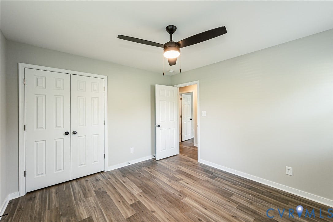 2702 Manchester Drive, New Birchett Estates, Prince George, VA 23875 Wood-finish flooring, white paneled doors, ceiling fan with integrated lighting, and light-colored wall paint