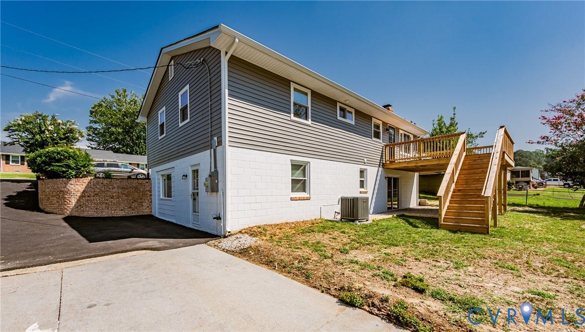 2702 Manchester Drive, New Birchett Estates, Prince George, VA 23875 Exterior featuring gray siding, white block foundation, and a wood deck with stairs