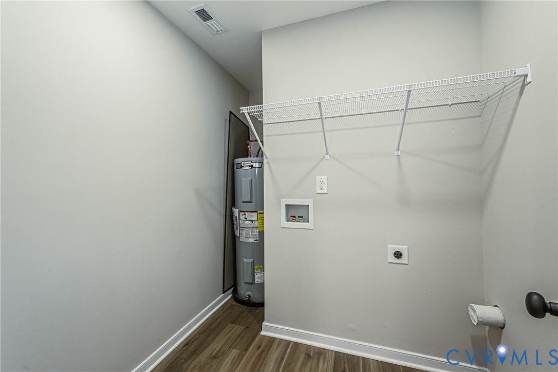 2702 Manchester Drive, New Birchett Estates, Prince George, VA 23875 Wood-finish flooring with white trim, wall-mounted wire shelving, and a water heater