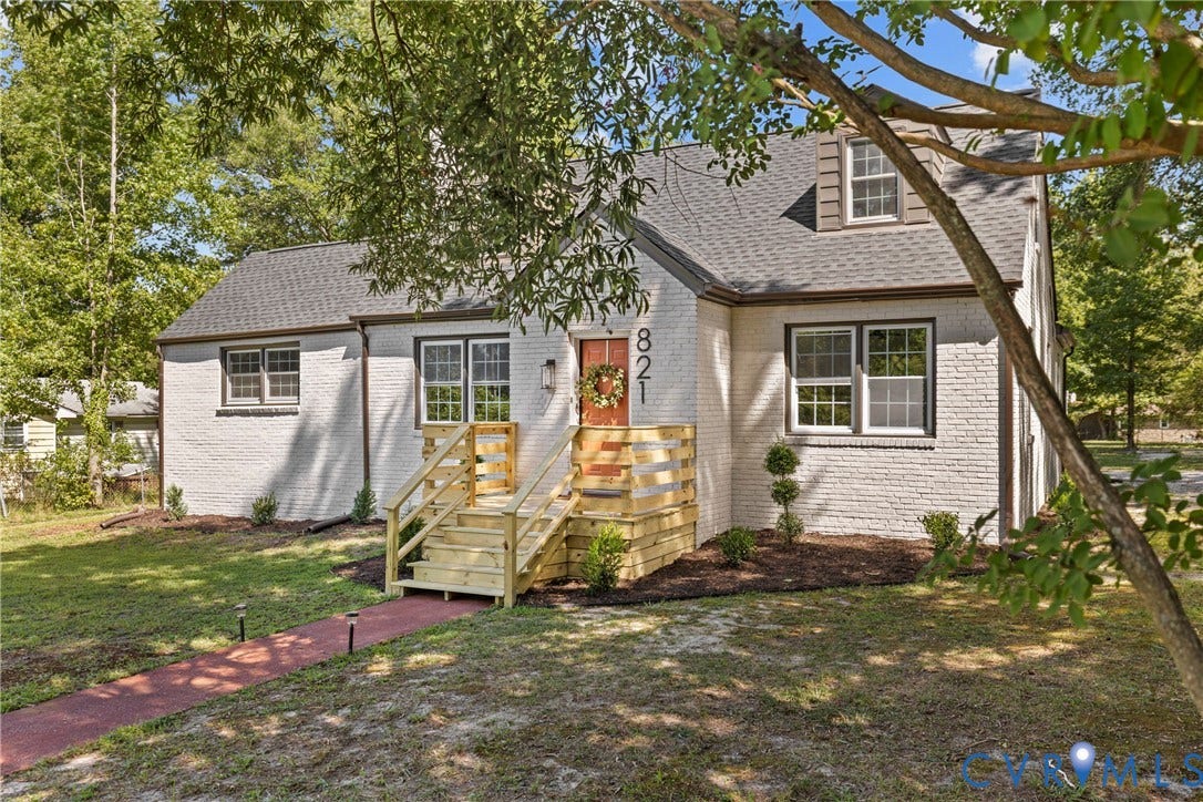 821 Fort Lee Road, North Dinwiddie, VA 23803 White brick exterior with dark trim windows, dark shingle roof, and a red brick pathway