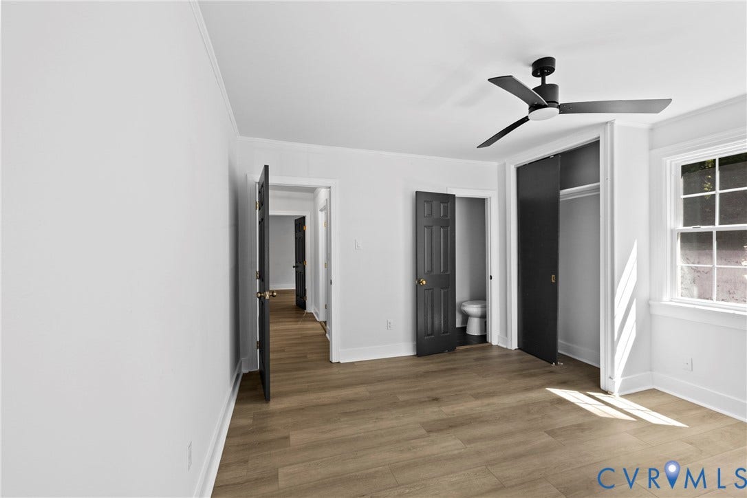 821 Fort Lee Road, North Dinwiddie, VA 23803 Wood-finish plank flooring, a modern black ceiling fan, white trim, and a window with multiple panes
