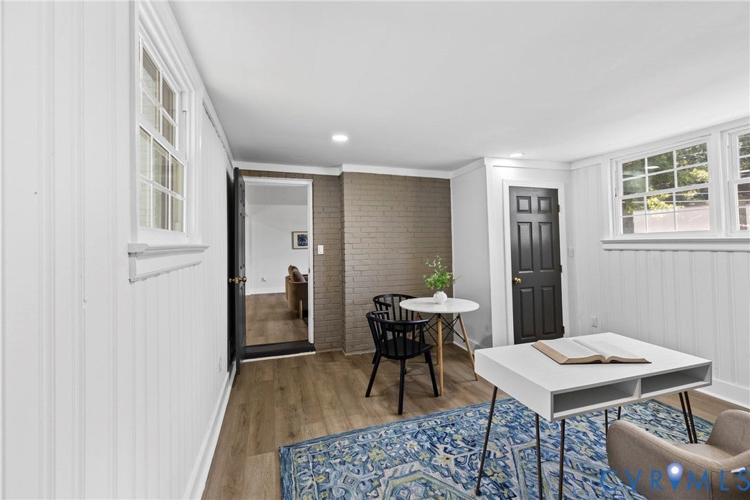 821 Fort Lee Road, North Dinwiddie, VA 23803 Wood-finish flooring, white beadboard wall paneling, painted brick accent wall, recessed lighting, and white-framed windows