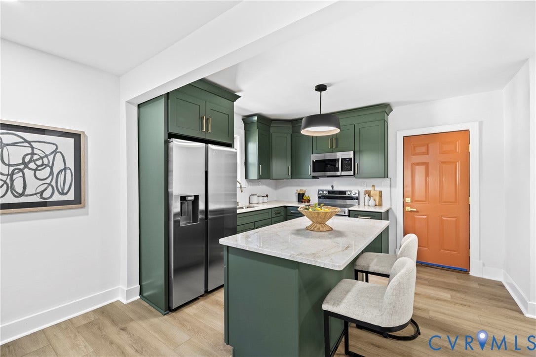 821 Fort Lee Road, North Dinwiddie, VA 23803 White shaker cabinets with gold-tone hardware, stainless steel appliances, central island with seating, pendant lighting, and wood-finish flooring