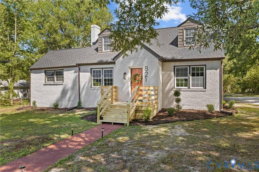 821 Fort Lee Road, North Dinwiddie, VA 23803 White brick exterior with dark trim windows, dormer windows, and a newly constructed wood deck entryway