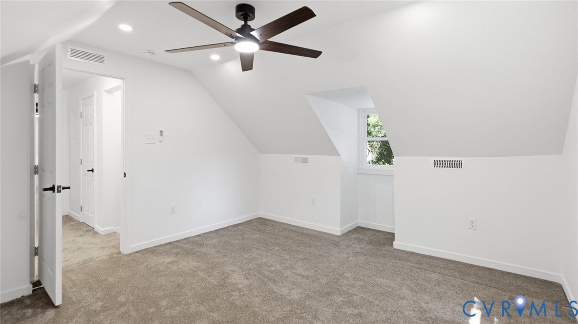 Carpeted room featuring a ceiling fan with integrated lighting, recessed lighting, and a window