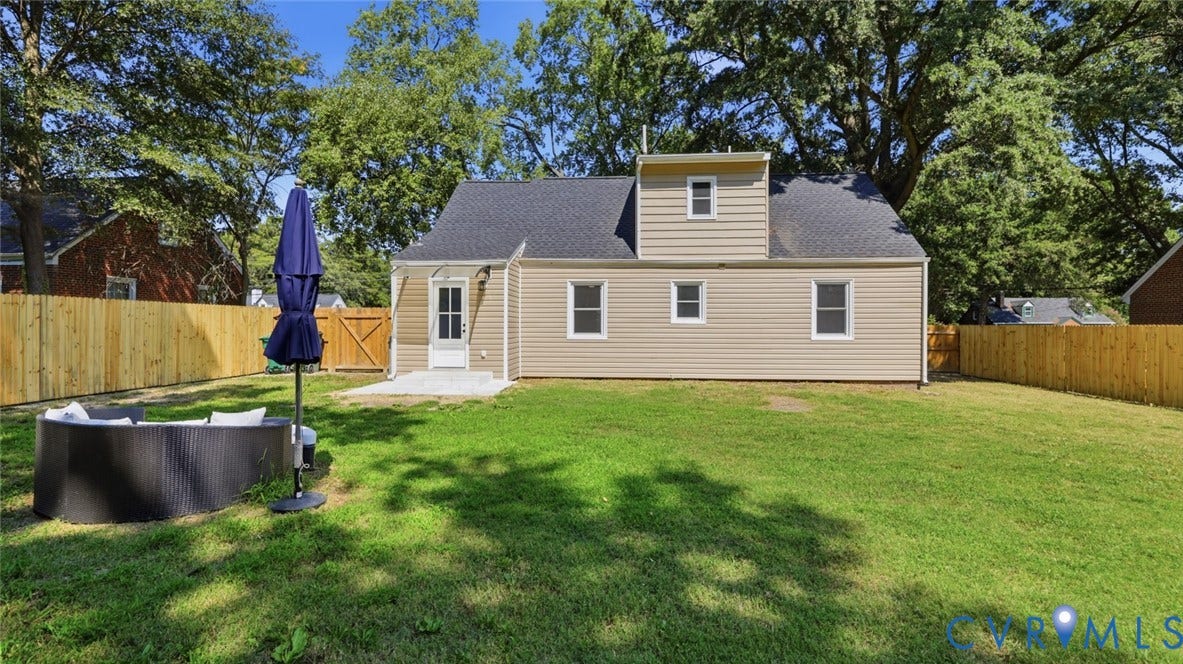Expansive backyard featuring a manicured lawn, new wood privacy fencing, and a concrete patio