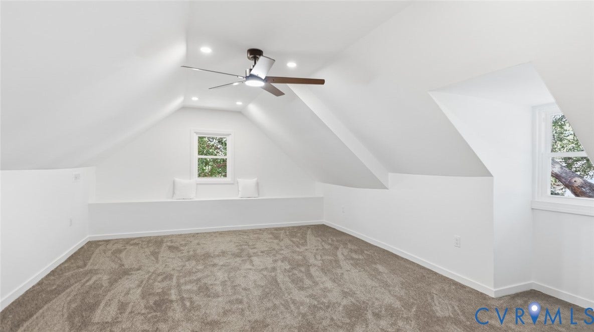 Carpeted room featuring a ceiling fan with light, recessed lighting, and multiple windows