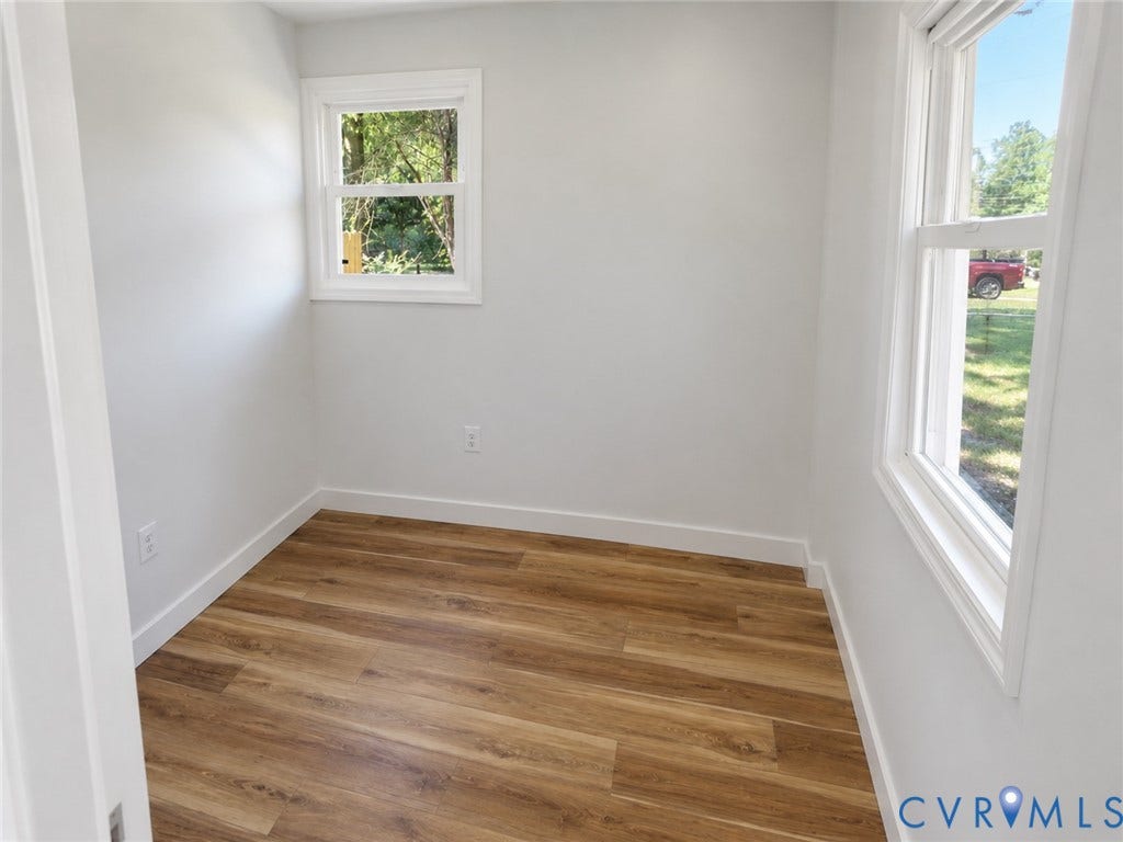 Wood-finish flooring with white trim and neutral wall paint