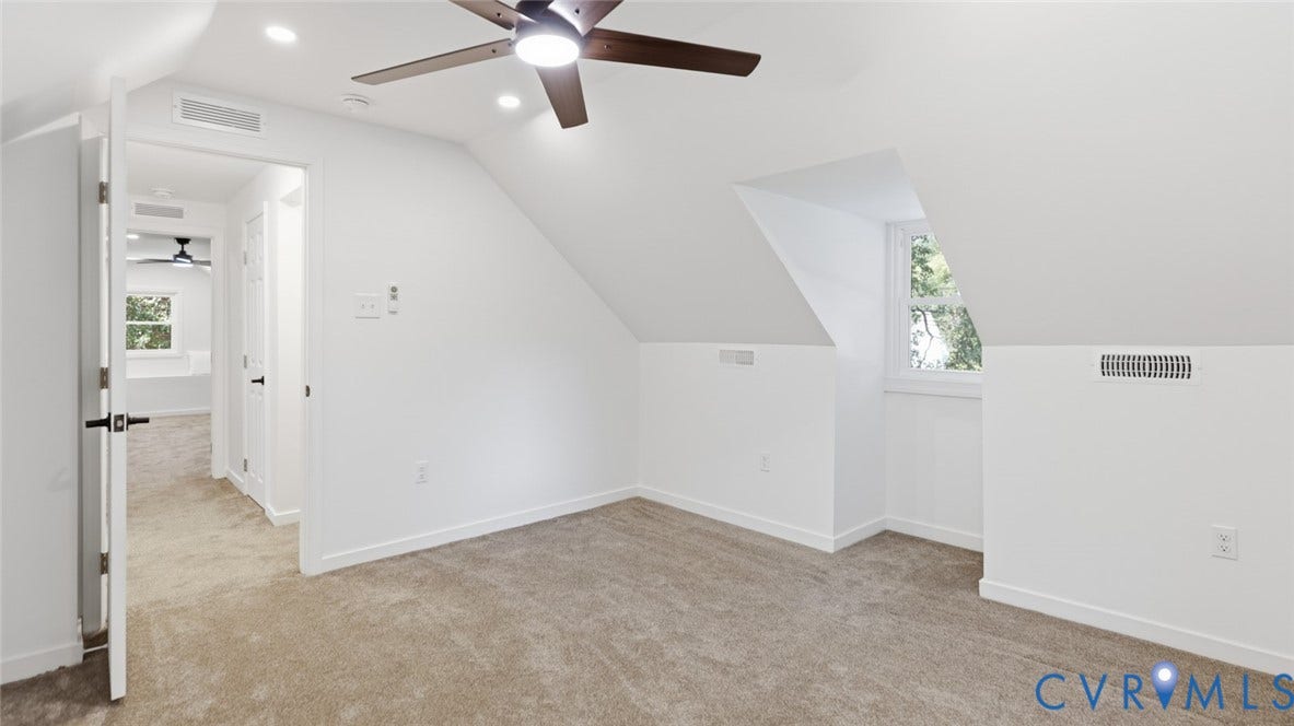 Sloped ceiling room featuring recessed lighting, a ceiling fan, a window, and carpet flooring