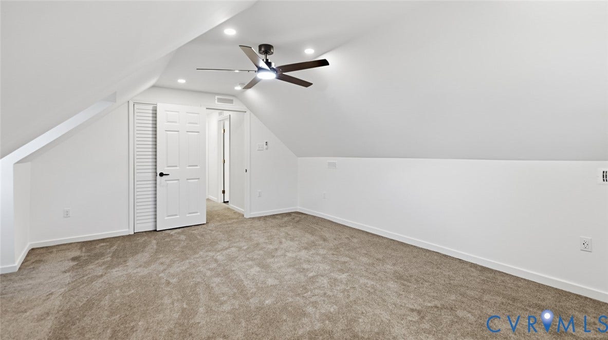 Sloped ceiling architecture featuring recessed lighting, a ceiling fan, plush carpet flooring, and white paneled doors