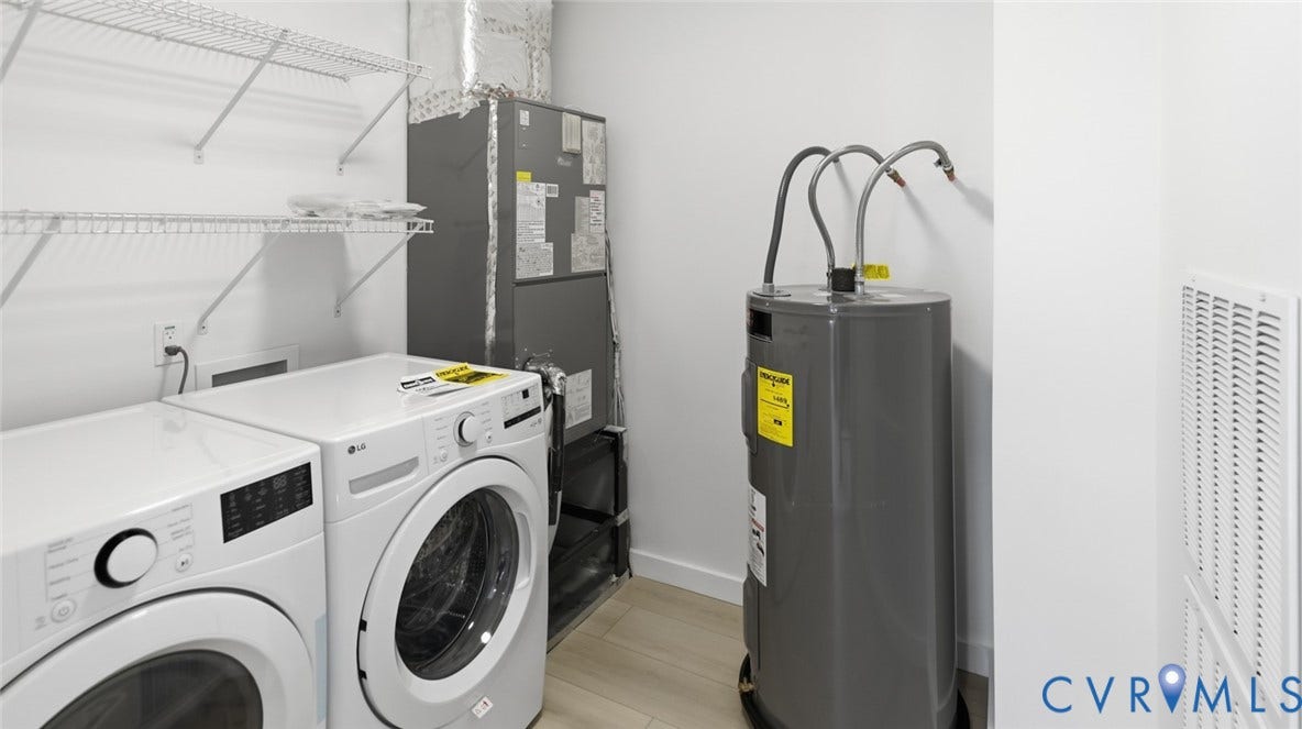 Utility area featuring a water heater, central air handler, and wire shelving
