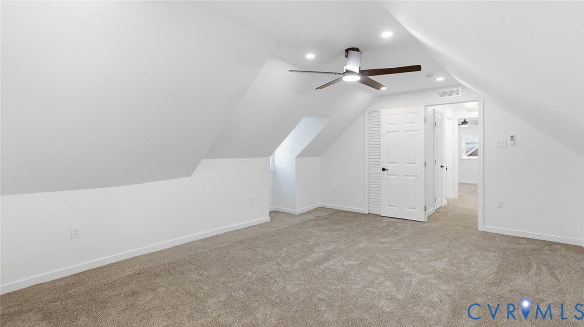 Carpet flooring, recessed lighting, ceiling fan, white paneled doors, and angled ceilings