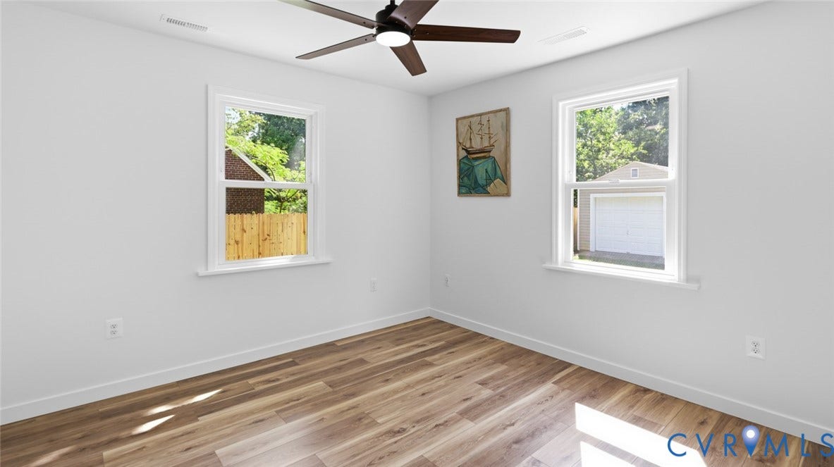 Wood-finish flooring, white walls, and a ceiling fan