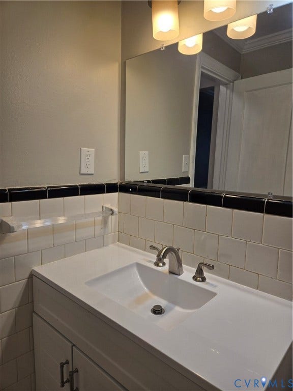 3427 W Franklin Street, Museum District, Richmond, VA 23221 Integrated vanity with a single basin, brushed nickel faucet, subway tile backsplash, and overhead light fixture